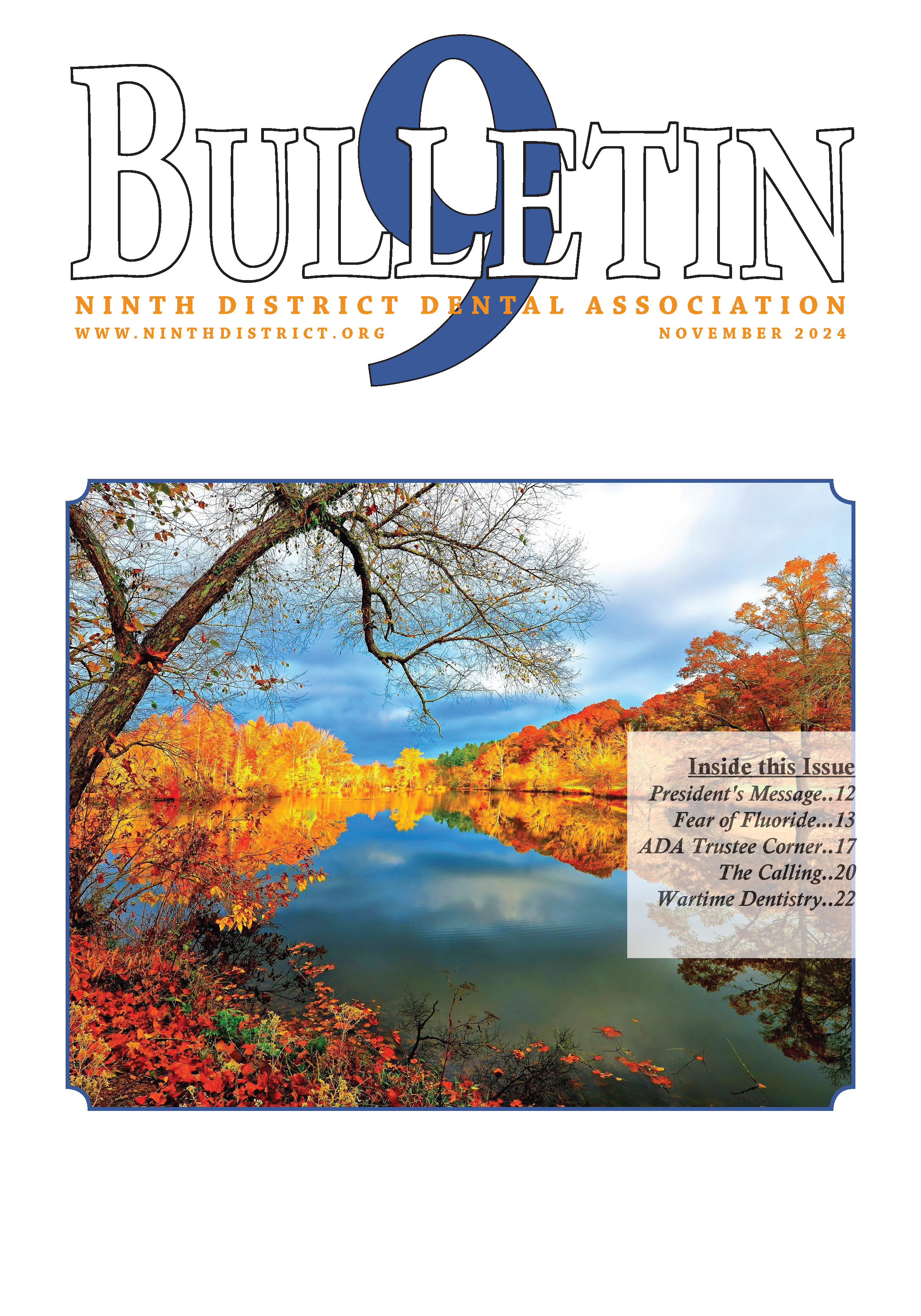 Photograph of a calm river reflecting a blue, cloudy sky with autumn trees changing colors.