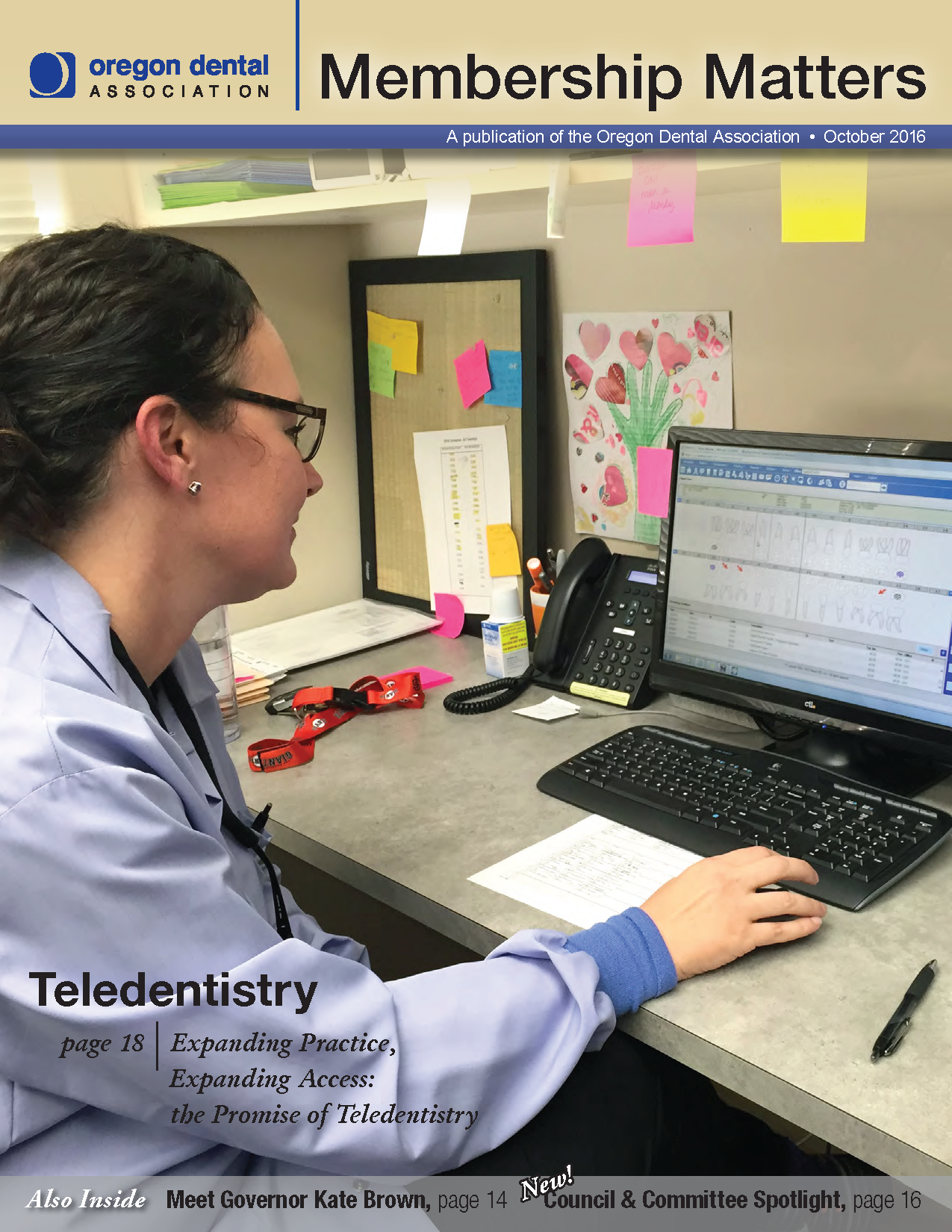Photo of dentist seated at a computer, reviewing an digital patient record