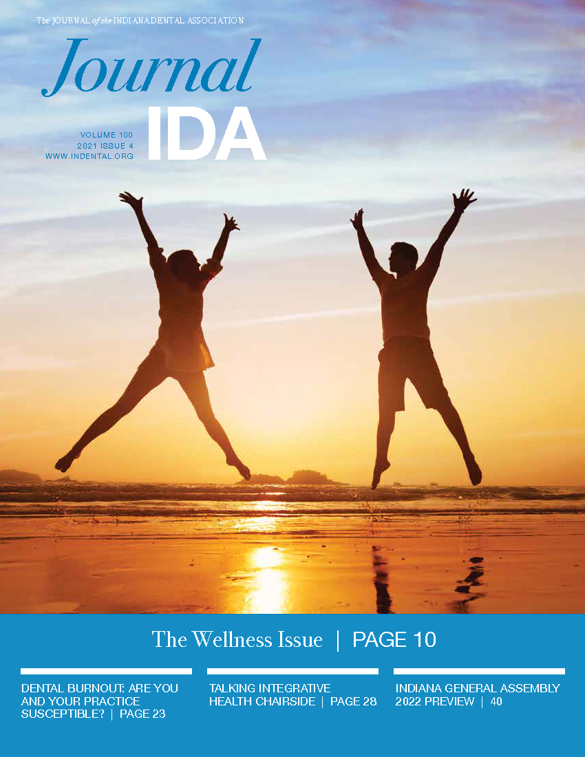 Photograph of two people simultaneously jumping in the air at a beach during sunset.