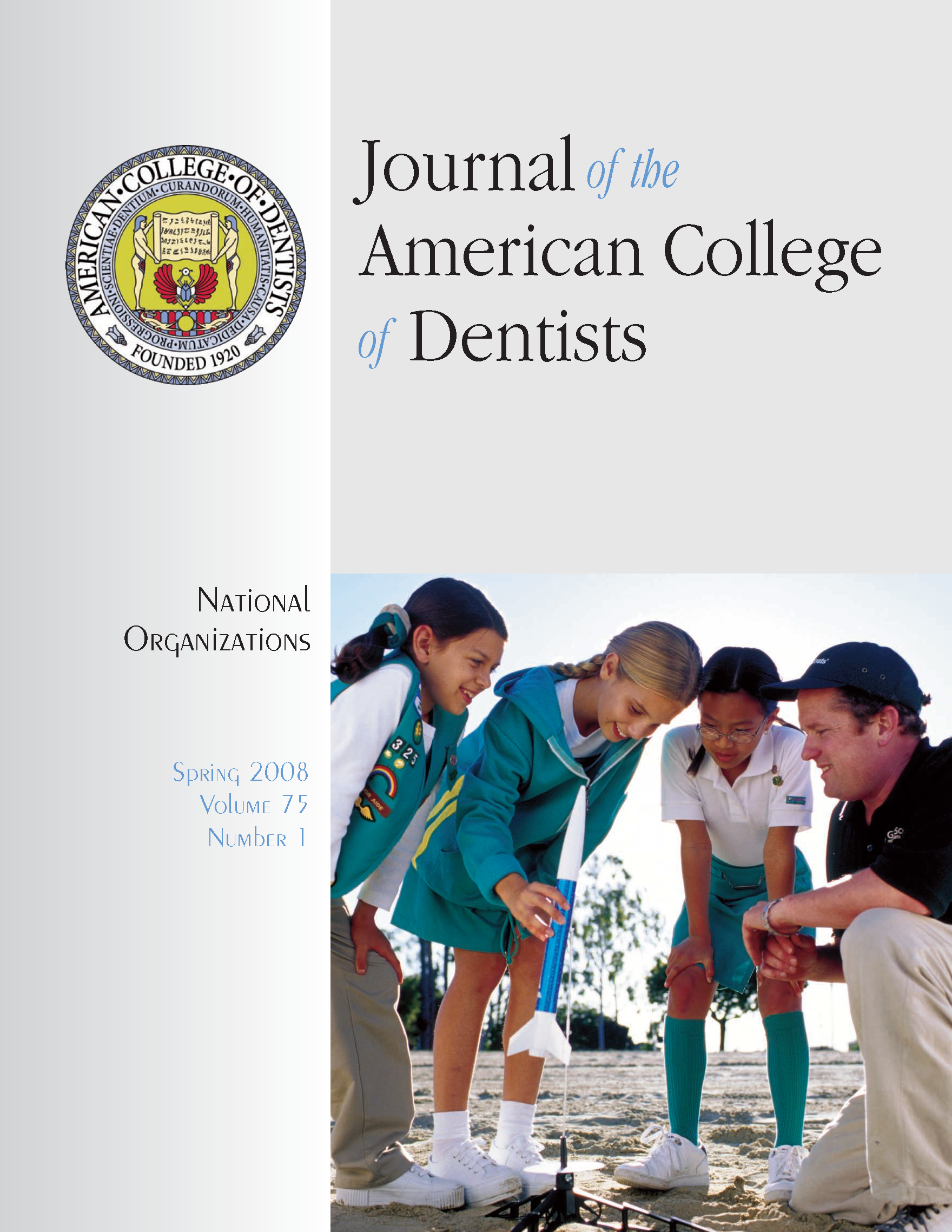 Photo of Girl Scouts looking at a small rocket with a teacher