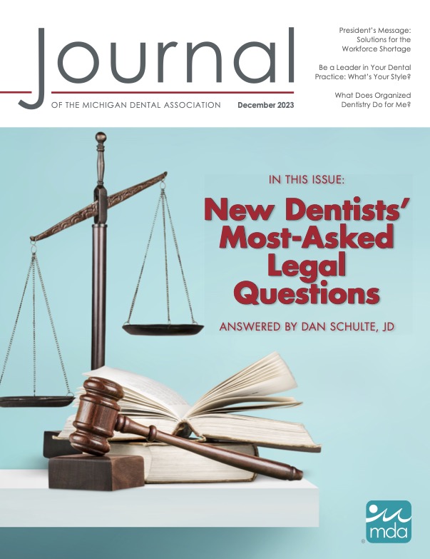 Cover of the Journal of the Michigan Dental Association with a set of metal justice scales, thick books, and a gavel.