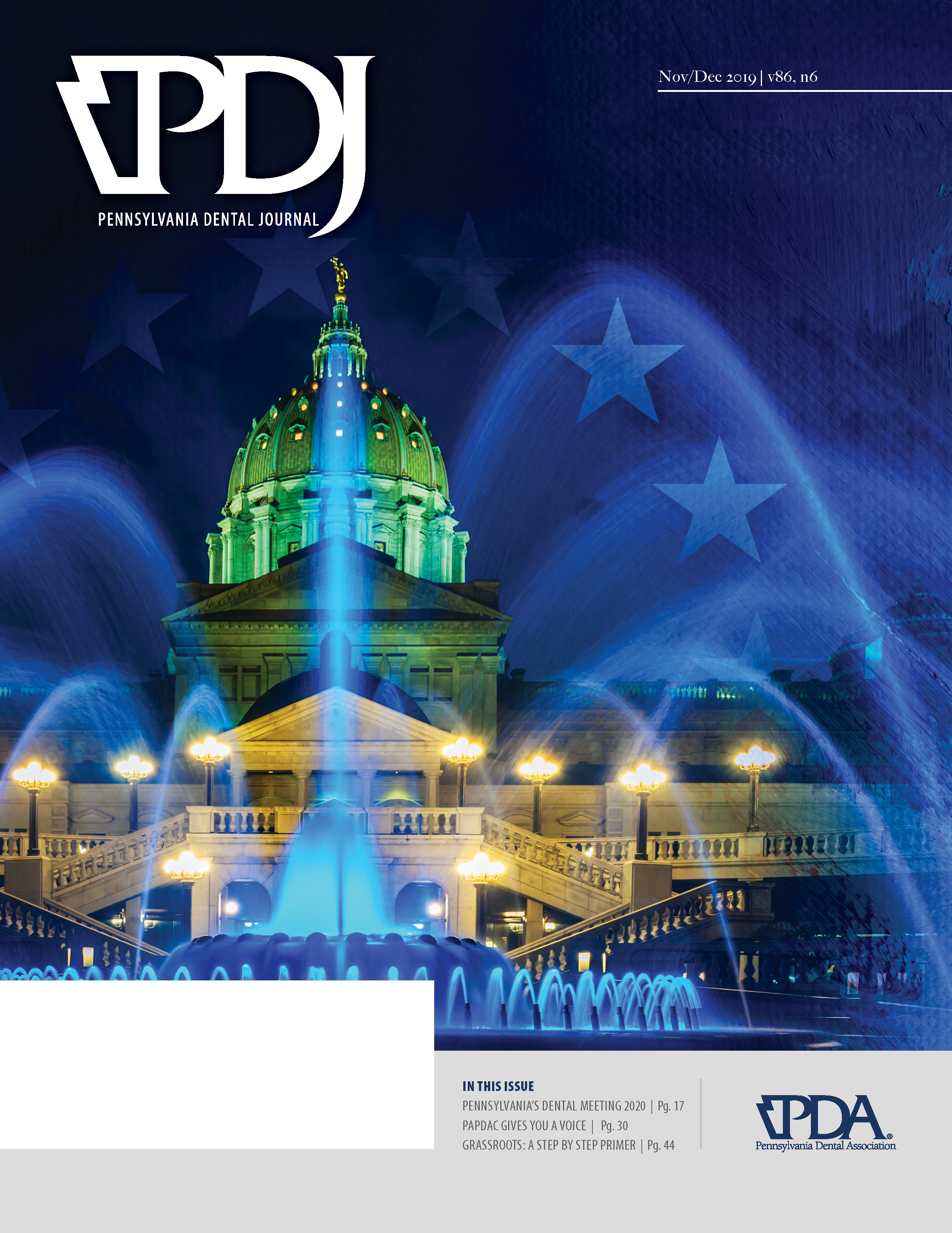 Image of the Pennsylvania state capitol building at night, see looking through the fountain in front of it