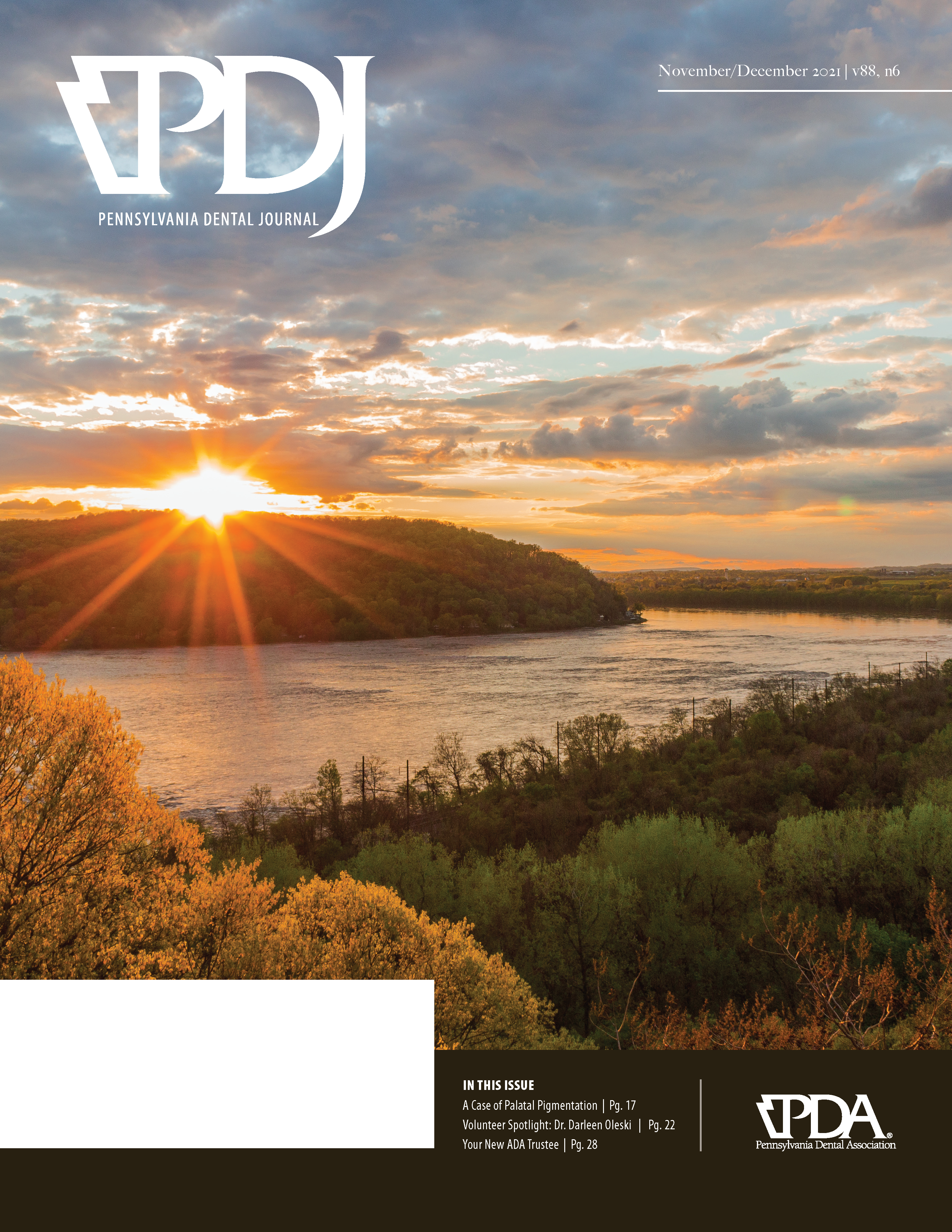 Photograph of a river with the sun setting in the distance behind a hill.