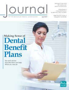 Cover of the Journal of the Michigan Dental Association featuring a person in a short sleeved white coat and shirt marking a manila file folder with a pen.