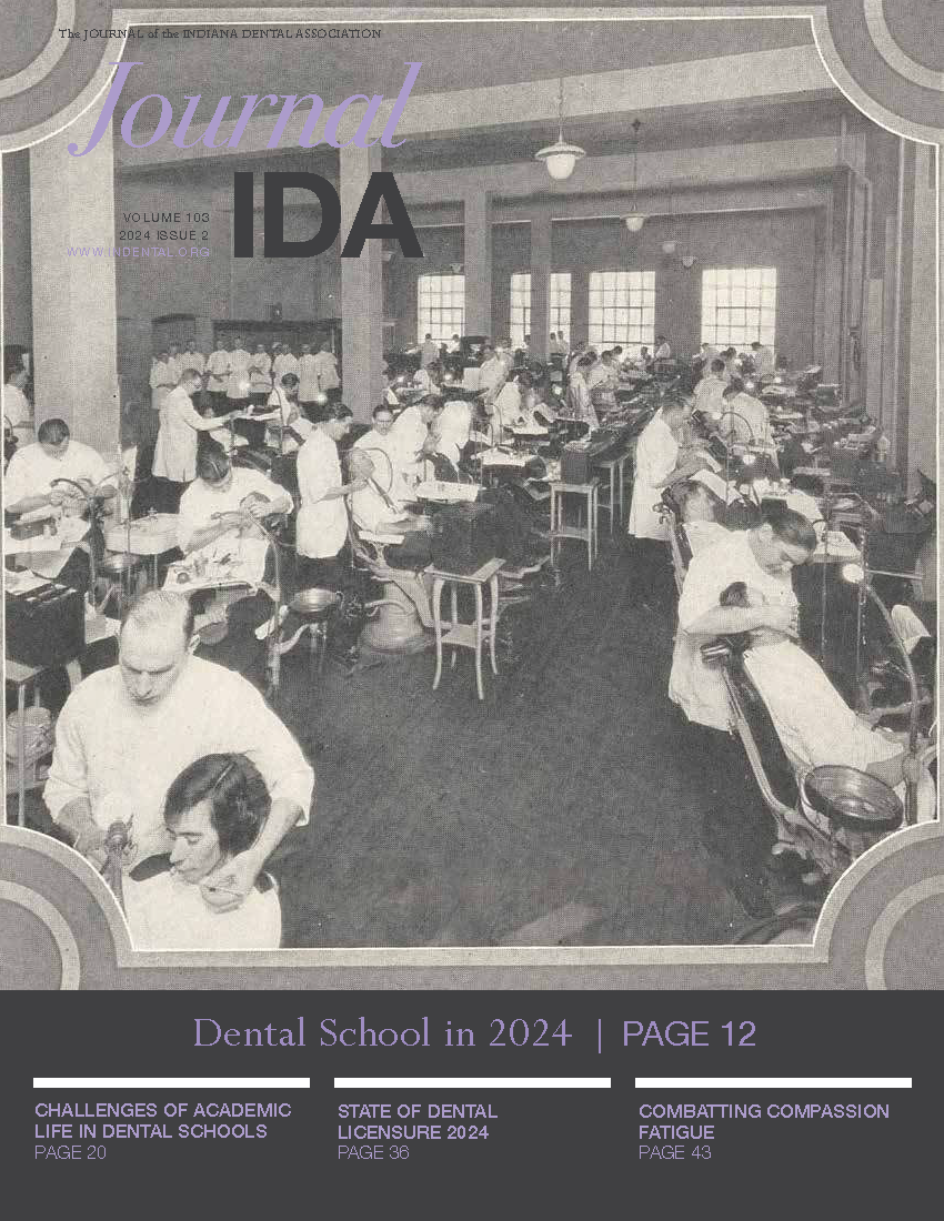 Black and white photograph of a dental school classroom in 1924 with students practicing on patients.
